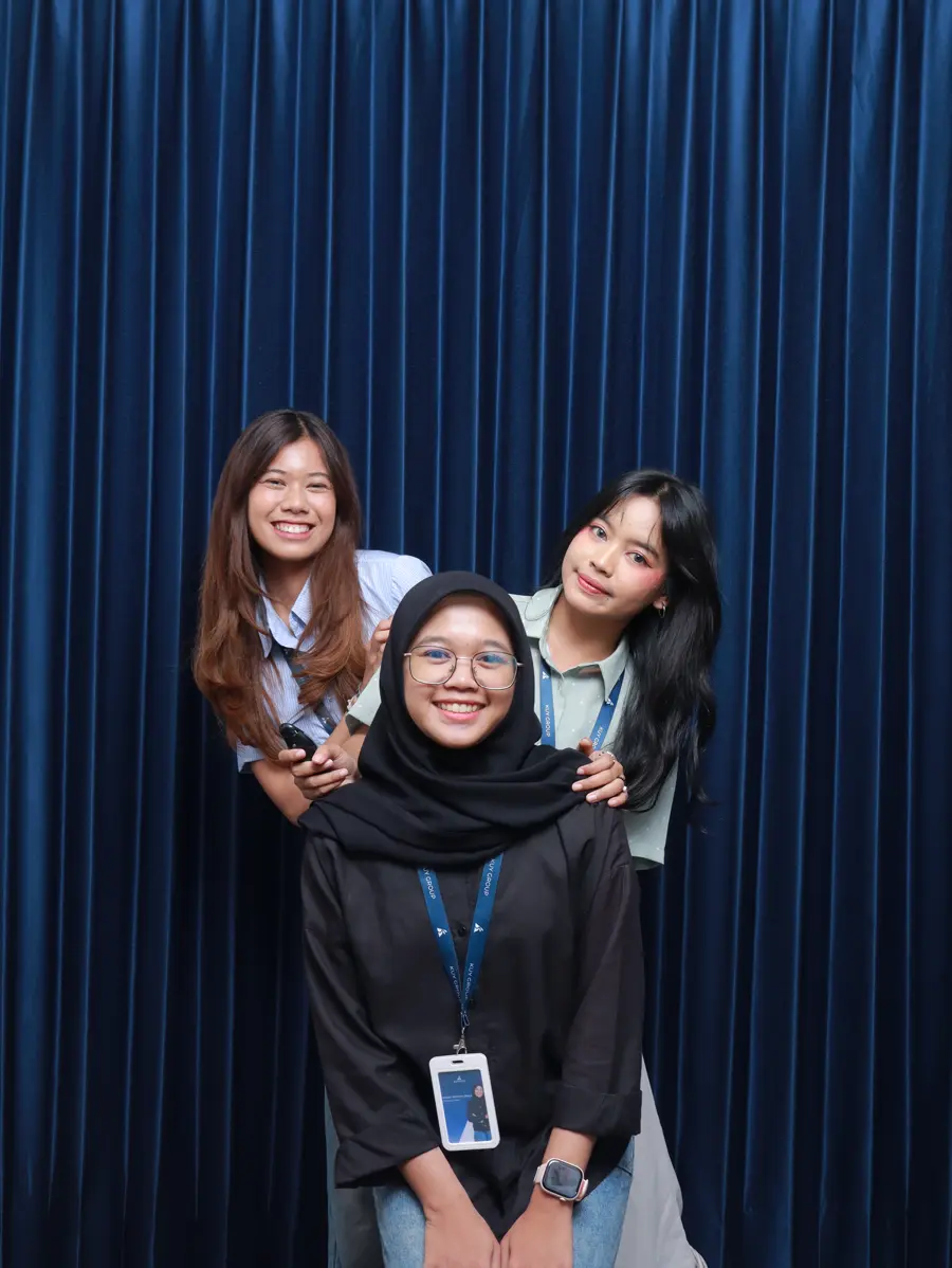 Three Marketing team members posing together, one in front of the other two