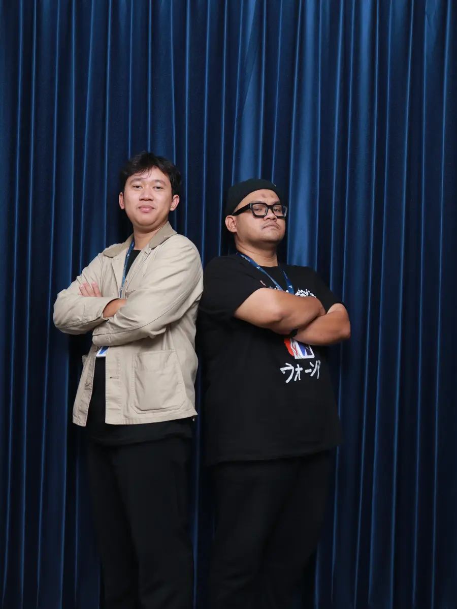 Two Operations team members standing back to back with arms crossed