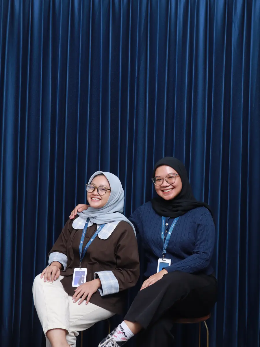 Two People & Culture team members sitting side by side, smiling