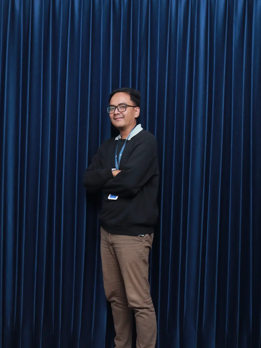 A store manager smiling with his arms crossed